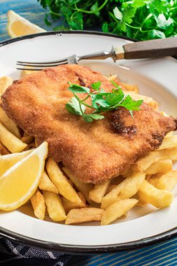 Tabağında patates kızartması olan kızarmış morina balığı..