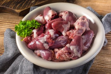 Fresh raw chicken hearts on wooden board. clipart