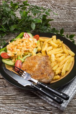 Geleneksel Polonya yemeği: kızarmış domuz pirzolası, patates kızartması ve salata ile servis edilir.. 