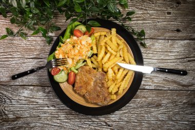 Geleneksel Polonya yemeği: kızarmış domuz pirzolası, patates kızartması ve salata ile servis edilir.. 