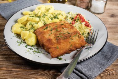 Akşam yemeğinde patates ve lahana turşusu salatası ile haşlanmış balık. Seçici odak.