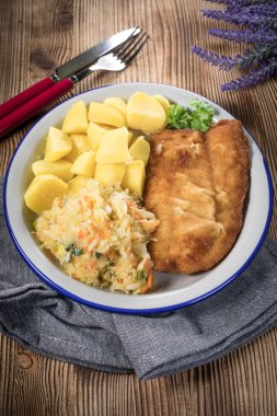 Akşam yemeğinde patates ve lahana turşusu salatası ile haşlanmış balık. Seçici odak.