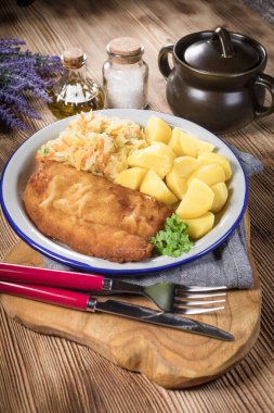 Akşam yemeğinde patates ve lahana turşusu salatası ile haşlanmış balık. Seçici odak.