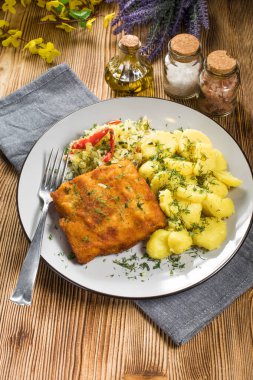 Akşam yemeğinde patates ve lahana turşusu salatası ile haşlanmış balık. Seçici odak.