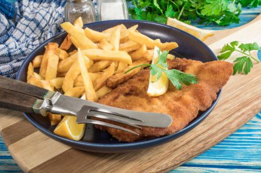 Tabağında patates kızartması olan kızarmış morina balığı..