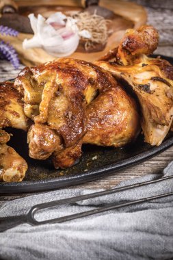 Çeyrek kızarmış tavuk ve dökme demir tava. Seçici odak.