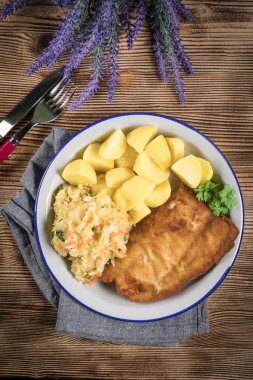 Akşam yemeğinde patates ve lahana turşusu salatası ile haşlanmış balık. Seçici odak.