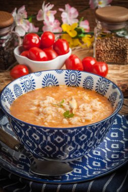 Mavi bir kase pilav ile taze domates çorbası.