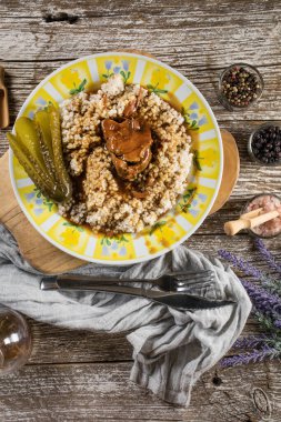 Et suyuna bulanmış domuz budu ve ahşap masada arpa..
