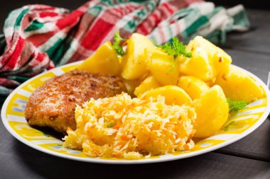 Patates ve lahana salatasıyla servis edilen kıymalı domuz pirzolası..