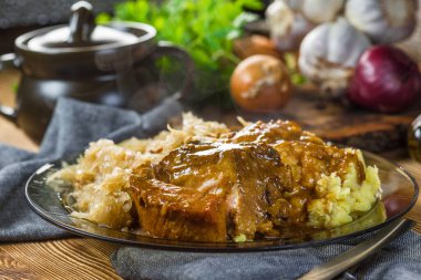 Fried ribs in sauerkraut served with boiled potatoes.  Selective focus.