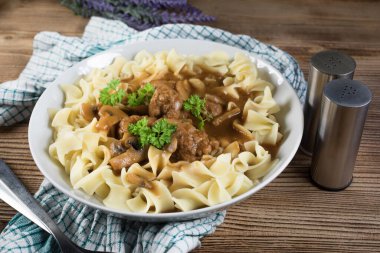 Tagliatelle yosunuyla servis edilen kendi soslu mantarlı domuz köftesi..