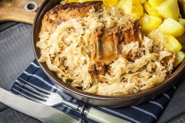 Kızarmış patatesle servis edilen lahana turşulu pirzola..