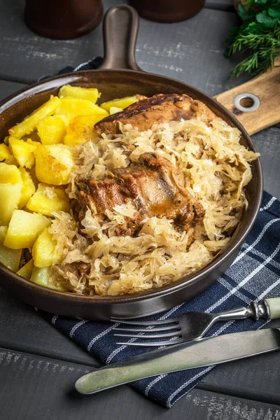 Kızarmış patatesle servis edilen lahana turşulu pirzola..