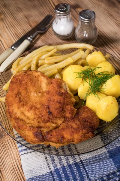 Breaded chicken with potatoes and yellow beans.