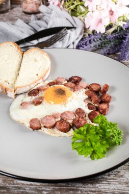 Kızarmış yumurta ve doğranmış sosis. Sığ alan derinliği.