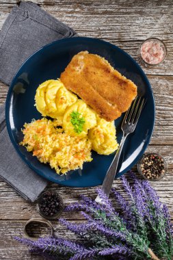 Haşlanmış patates ve sebze salatasıyla servis edilen kızarmış morina filetosu..