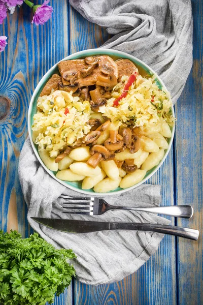 stock image Braised pork loin with mushrooms, served with Silesian dumplings and sauerkraut salad.