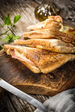 Kesme tahtasında kızarmış peynirli sandviç. Sığ alan derinliği.