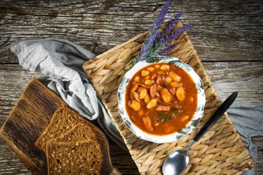 Domates soslu fasulye, pastırma ve sosis. Seçici odak.