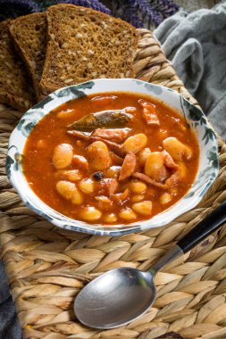 Domates soslu fasulye, pastırma ve sosis. Seçici odak.