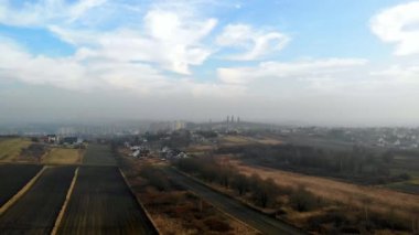 Tarlanın üzerinden uçmak. Uzakta görünen binalar ve kilise kuleleri.