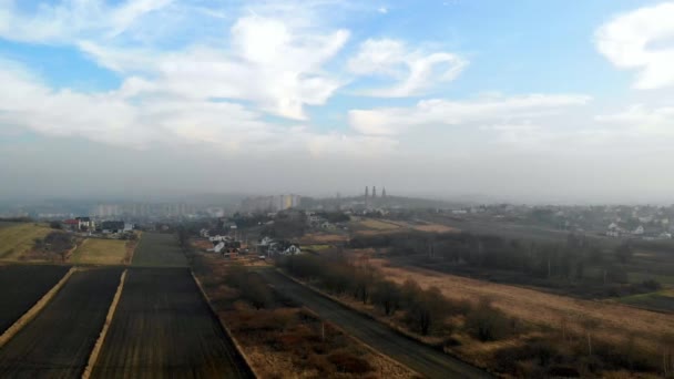 Survoler un champ labouré. Au loin les bâtiments visibles et les tours d'église .