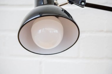 Anglepoise lamba. Ampul ve ışık beyaz tuğla arka plan ile yakından