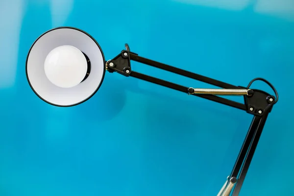 Lampu Anglepoise. Cahaya logam hitam retro melihat penampil dengan latar belakang biru — Stok Foto