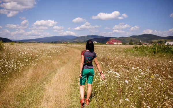 Chica caminando en un campo amarillo en Ucrania Cárpatos — Foto de Stock