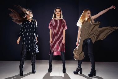 Üç benzersiz modelleri ile sıradışı bir makyaj ve özgün giysili bir podyum üzerinde poz