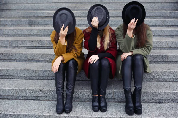 Stilvolle Mädchen in modischen Mänteln, Schals, Hüten und Lederschuhen in der Treppe zur Kombüse — Stockfoto