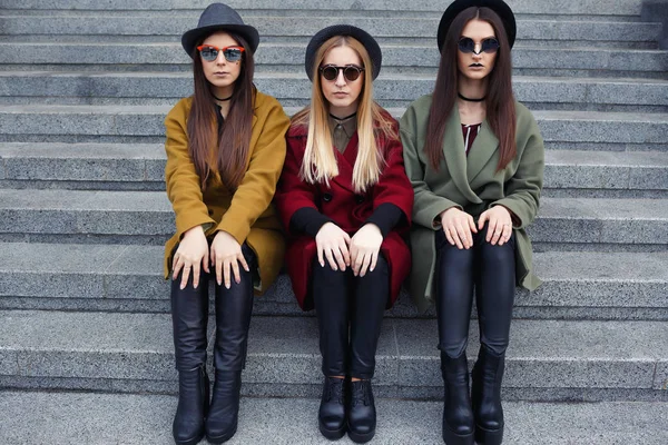 Chicas elegantes con maquillaje inusual en abrigos de moda, bufandas, sombreros y zapatos de cuero en las escaleras a la cocina — Foto de Stock