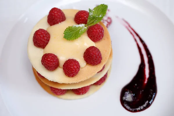 Exquisite dessert with cookies, cream and raspberries