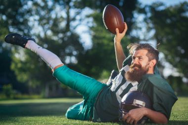 Amerikan futbolu oyuncusu yeşil bir spor futbol sahasına siyah uzun sakallı tren resmi