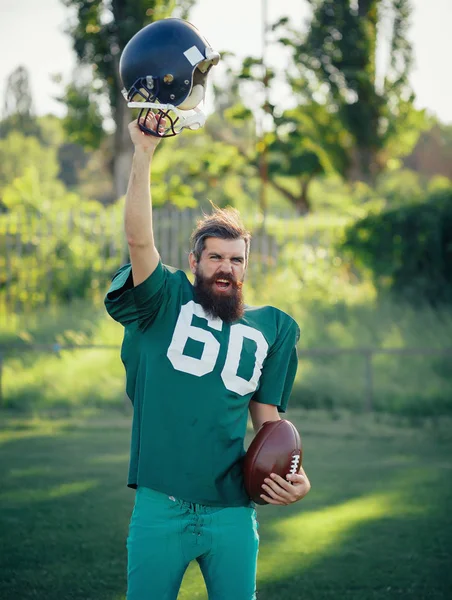 American football player in a green sport uniforms with black long beard trains on the football field