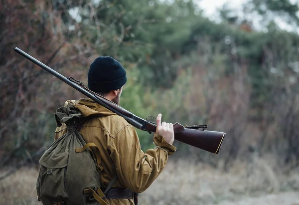 Bebaarde hunter met professionele apparatuur, wandelen in het bos — Stockfoto