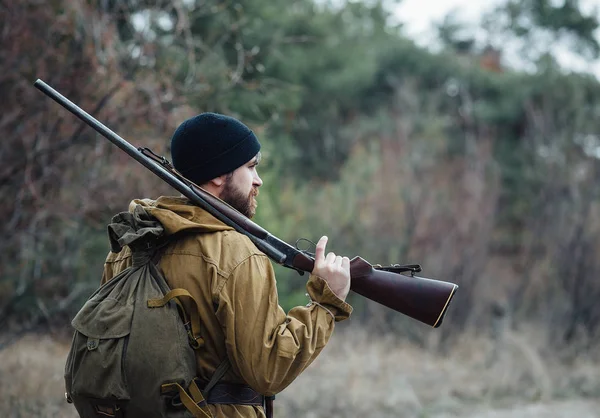 Bebaarde hunter met professionele apparatuur, wandelen in het bos — Stockfoto