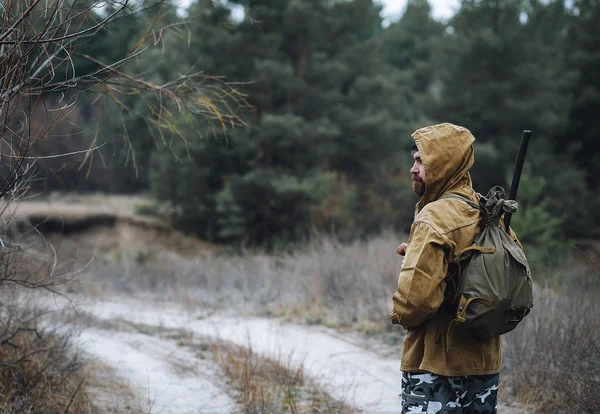 Bärtiger Jäger mit professioneller Ausrüstung im Wald unterwegs — Stockfoto