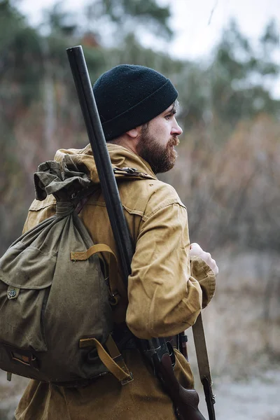 Skäggiga jägare med professionell utrustning promenader i skogen — Stockfoto