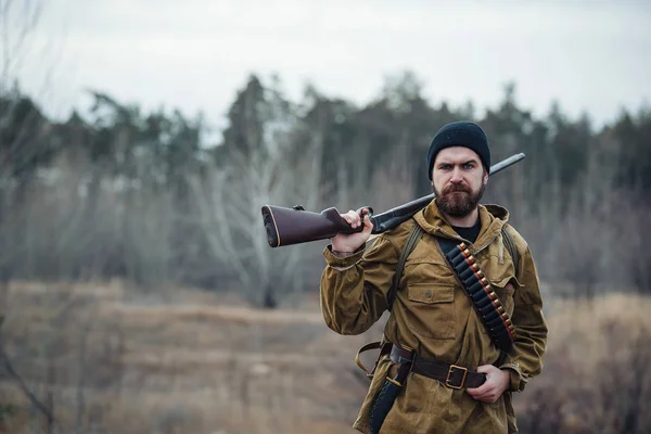 Skäggiga jägare med professionell utrustning promenader i skogen — Stockfoto