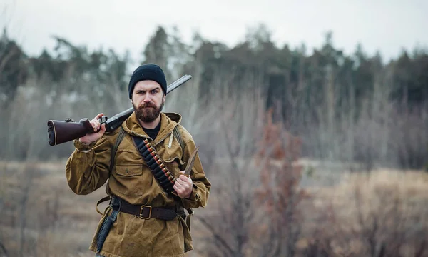 Chasseur barbu avec équipement professionnel marchant dans les bois — Photo