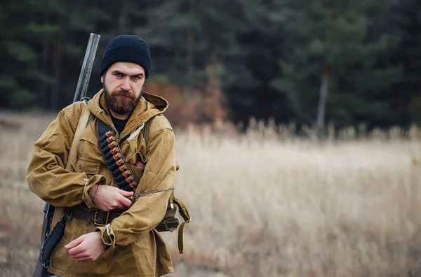 Bearded hunter with professional equipment walking in the woods — Stock Photo, Image