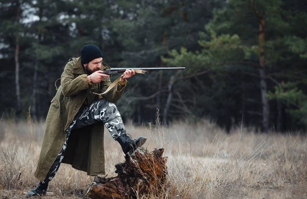 Bearded hunter with professional equipment walking in the woods — Stock Photo, Image