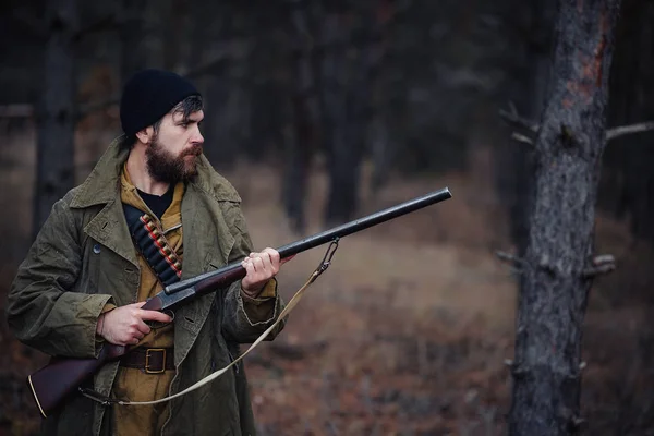 Bebaarde hunter met professionele apparatuur, wandelen in het bos — Stockfoto