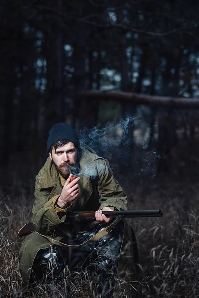 Bärtiger Jäger mit professioneller Ausrüstung im Wald unterwegs — Stockfoto