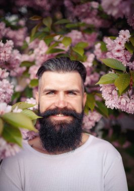 Bir neşeli sakallı adam güzel bıyıklı sakura yakınlarında şık bir hairdress çıkar