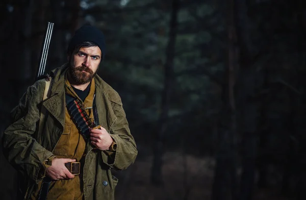 Skäggiga jägare med professionell utrustning promenader i skogen — Stockfoto