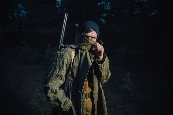 Cazador barbudo con equipo profesional caminando por el bosque — Foto de Stock