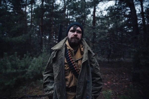 Bärtiger Jäger mit professioneller Ausrüstung im Wald unterwegs — Stockfoto